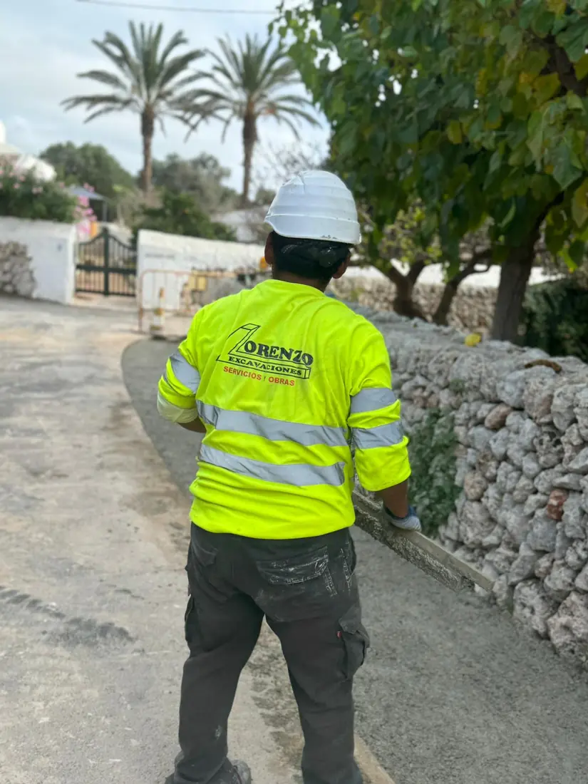 Operario de Lorenzo Excavaciones junto a una pared seca en una finca de Menorca