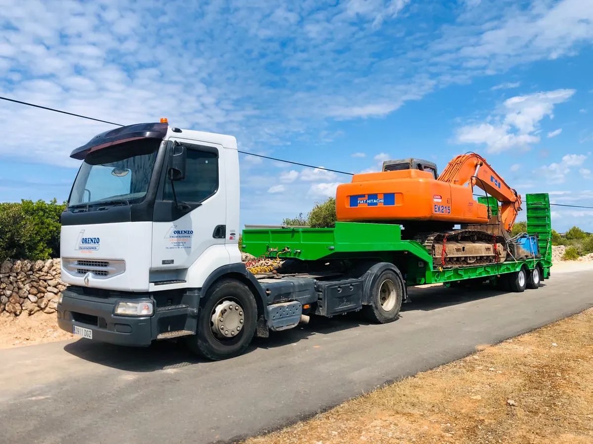 Góndola portamaquinaria transportando una excavadora de cadenas por carretera